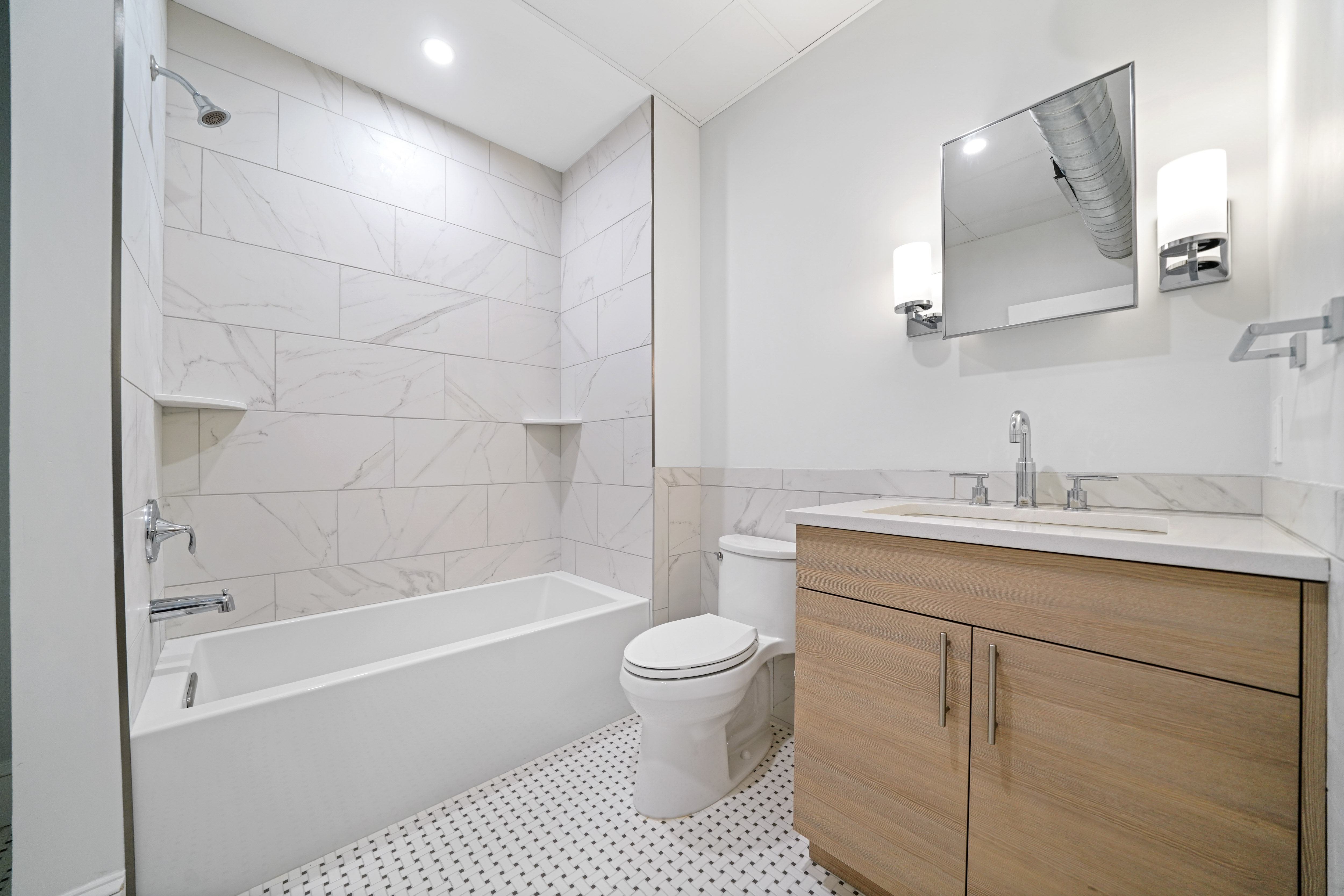 a bathroom with a toilet sink and shower and a mirror